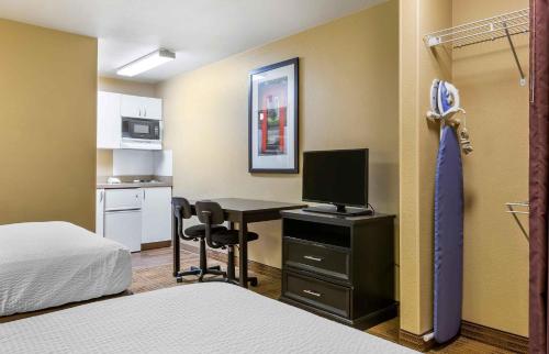 a room with a desk with a computer and a bed at Extended Stay America Suites - Albuquerque - Airport in Albuquerque