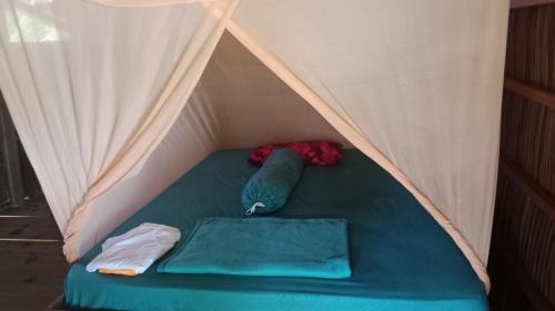 a tent with a green bed in it at War Nyampun Homestay in Waisai
