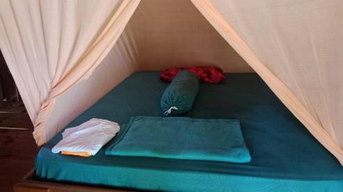 a bed in a tent with two pillows at War Nyampun Homestay in Waisai