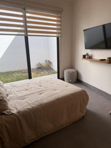 a bedroom with a large bed and a large window at Cielo Suites in Oaxaca City