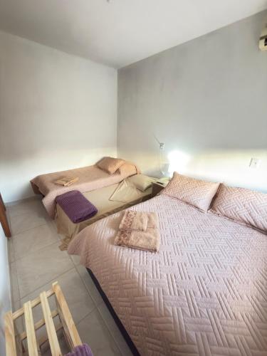 a bedroom with two beds with towels on them at Casa Verde próxima a BR 290 in São Gabriel