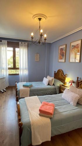 three beds in a room with blue walls at Casa Pilar Casa Llara, En el paraíso, cerca de todo in Ujo