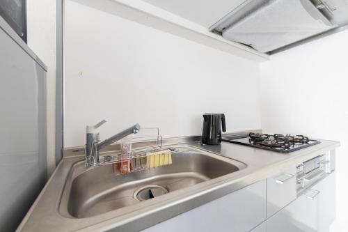 a stainless steel sink in a kitchen with a stove at エドモダンステイ Edo Modern Stay 01 in Tokyo