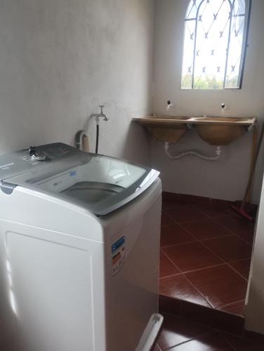 a bathroom with a sink and a washing machine at Confort Suite 01 in Contagem