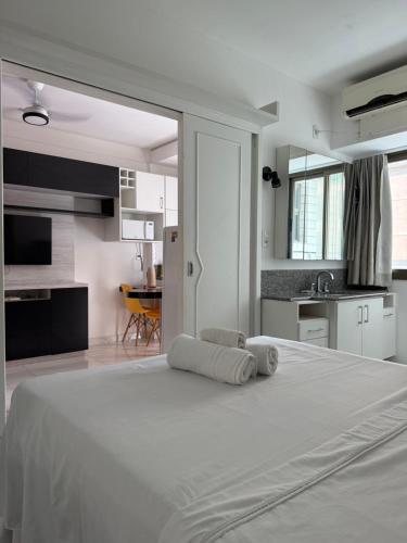 a large white bed in a room with a kitchen at Ocean Flat com vista pro mar 604 in Vila Velha