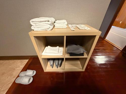 a small table with towels and shoes on it at Kokusai Towns Inn in Naha