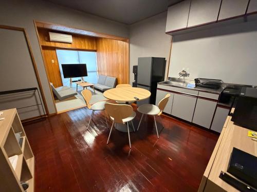 a small kitchen with a table and chairs in a room at Kokusai Towns Inn in Naha