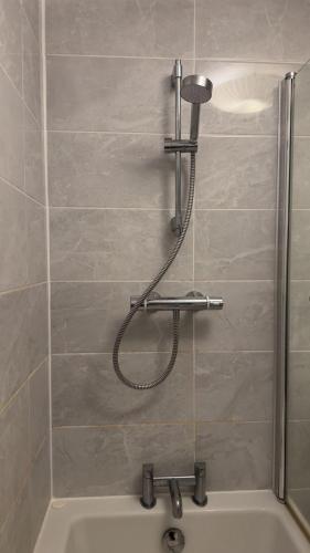 a shower in a bathroom with a tub at 40 Kennett gardens in Gloucester