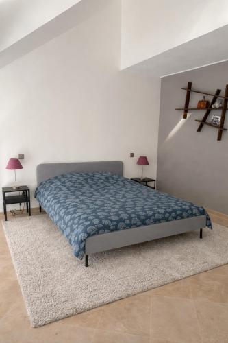 a bedroom with a bed with a blue comforter at Charming & Cosy duplex - city in Luxembourg