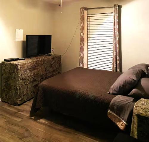 a bedroom with a bed and a flat screen tv at Home Away in Grand Prairie