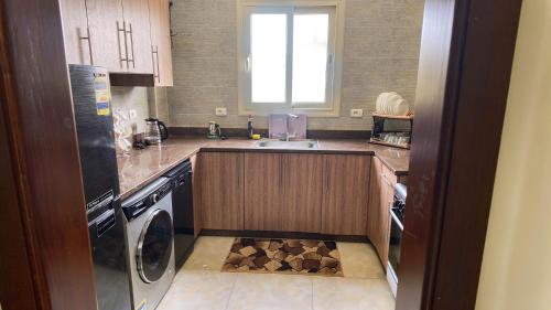 a small kitchen with a sink and a dishwasher at لوزان ابارتمنت in Dawwār Siwākah