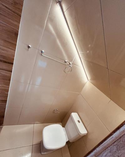 a bathroom with a white toilet and aflush at Retro Flat in Caruaru
