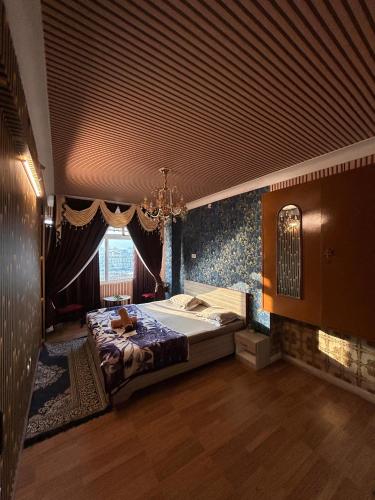 a bedroom with a large bed and a chandelier at Tamasha Udaipur in Udaipur