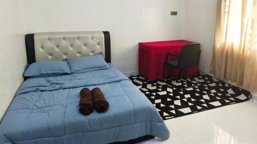 a bed with a pair of shoes sitting on it at Casa Ariana Machang 3B3R in Macang