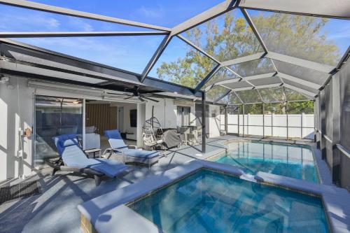 a swimming pool with a glass roof over a patio at Luxury Style townhome with Pool - 1 Miles to Bucs Stadium in Tampa