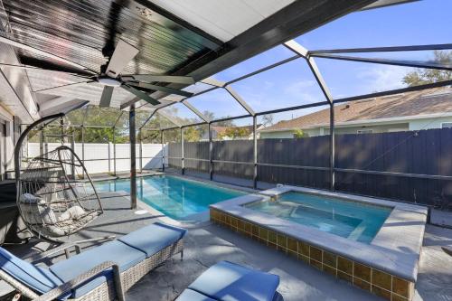 a swimming pool with a pergola next to a fence at Luxury Style townhome with Pool - 1 Miles to Bucs Stadium in Tampa