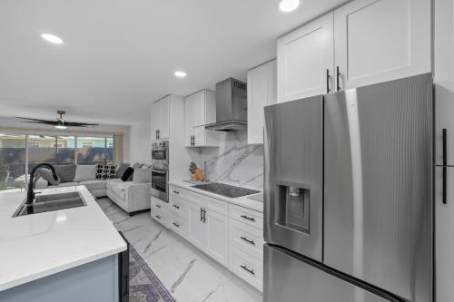 a kitchen with white cabinets and a stainless steel refrigerator at Luxury Style townhome with Pool - 1 Miles to Bucs Stadium in Tampa