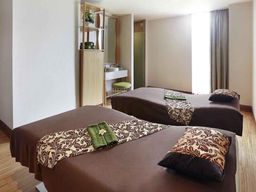 a hotel room with two beds in a room at Novotel Tangerang in Tangerang