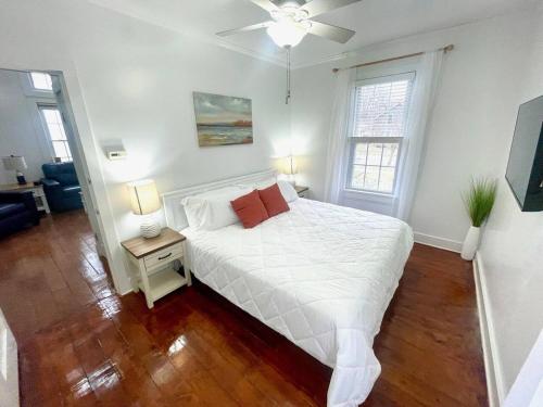 a bedroom with a white bed and two windows at Coastal Cape Cod w/ King Bed, Game Room, & Bikes! in Vermilion