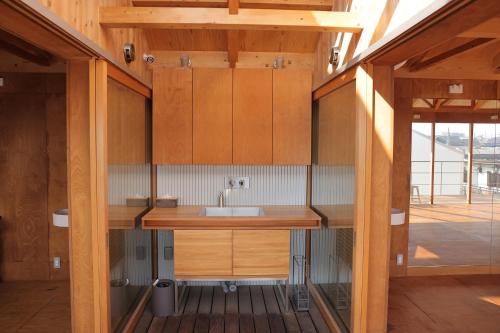 a kitchen with wooden cabinets and a sink at Inn Azur in Yamatotakada