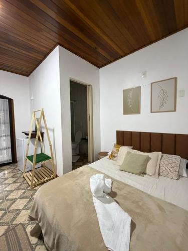 a bedroom with a large bed and a wooden ceiling at Riso Suítes - Jantar Romântico in Santo Antônio do Pinhal