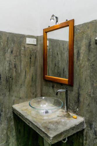 a bathroom with a sink and a mirror at Sanctuary Cove Guest House in Polonnaruwa