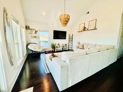 a living room with a white couch and a tv at Dockside Dream Home for 10 in Galveston