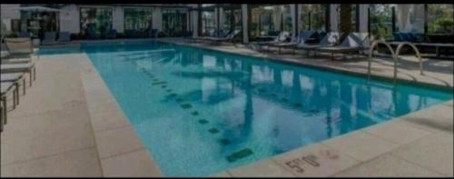 a large swimming pool with blue water in a building at Spacious 2 bed 2 bath, Pool, Hottub, Wifi, 24 hr Fitness, Parking in Los Angeles