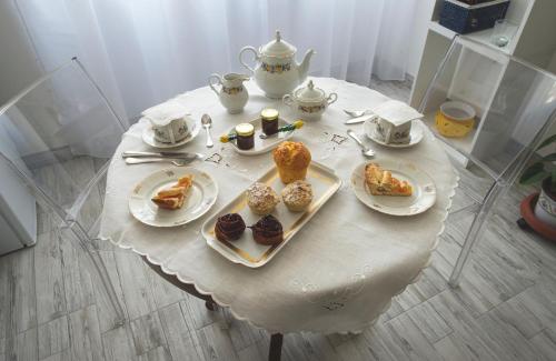 a table with plates of pastries and cups on it at A Casa di Renata in Cosenza