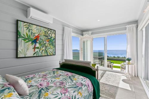 a bedroom with a bed and a large window at Waves at Warilla in Barrack Point