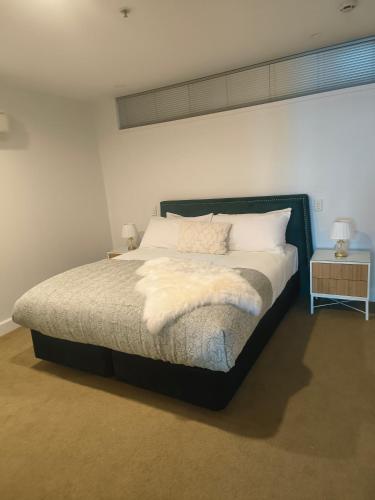 a bedroom with a large bed with white sheets and pillows at 204 The Sands in Nelson
