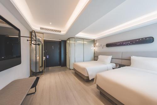a hotel room with two beds and a tv at Atour Light Hotel Hangzhou Xiasha in Hangzhou