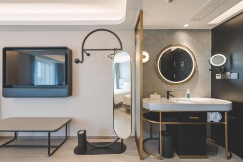 a bathroom with a sink and a mirror at Atour Light Hotel Hangzhou Xiasha in Hangzhou