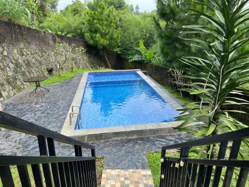 a swimming pool in the middle of a garden at Villa Kay Mountain in Bogor