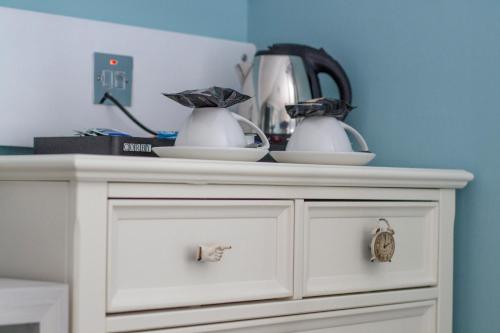 a white cabinet with two dishes on top of it at Bingham Townhouse Hotel in Bingham
