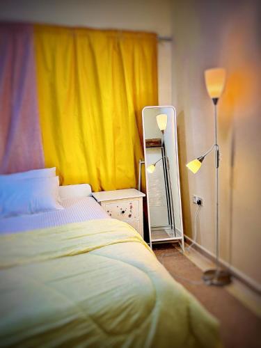 a bedroom with a bed and a yellow curtain at Studio appartment well Furnished in Ajman