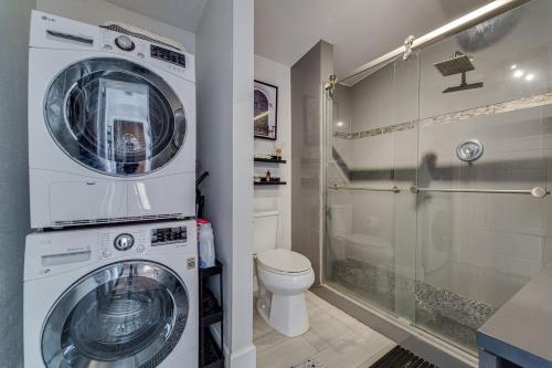 a washer and dryer in a bathroom with a toilet at Cozy bungalow with Luxe Yard, Firepit, Pergola Area in Tampa