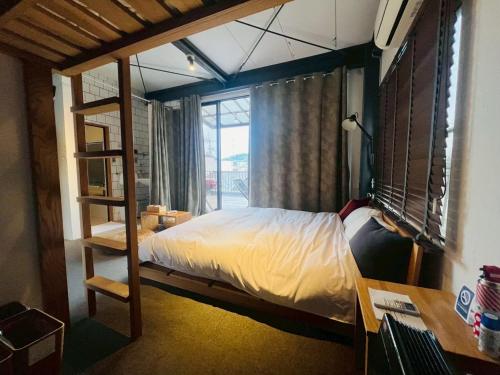 a bedroom with a bunk bed with a ladder at Onomichi SINGAI HOSTELS in Onomichi