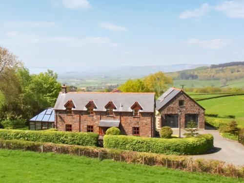a large brick house in a field at Green Lane Cottage in Newtown