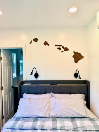 a bedroom with a bed with cow heads on the wall at Hibiscus Hale - Perfect for 2! in Waialua