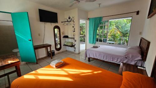 ein Schlafzimmer mit einem Bett und einem großen Fenster in der Unterkunft Hotel Henry Bacalar in Bacalar