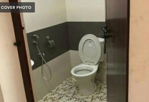 a bathroom with a toilet in a shower stall at ABRU'S Holidays International Travelers in Alleppey