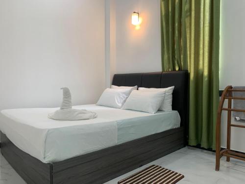 a bed in a room with a green curtain at Nomin Villa in Kottagoda