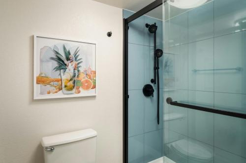 a bathroom with a glass shower stall next to a toilet at Sheraton Orlando Lake Buena Vista Resort in Orlando