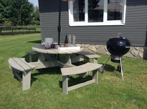 ein Picknicktisch und Grill neben einem Haus in der Unterkunft Le Chalet de Marguerite in Francorchamps