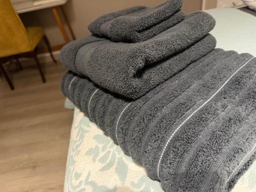 a pile of gray towels sitting on top of a couch at 12a Infinity Guesthouse in Pietermaritzburg