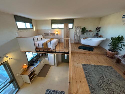 two views of a bathroom with a loft bed and a sink at מים במדבר in Zuqim