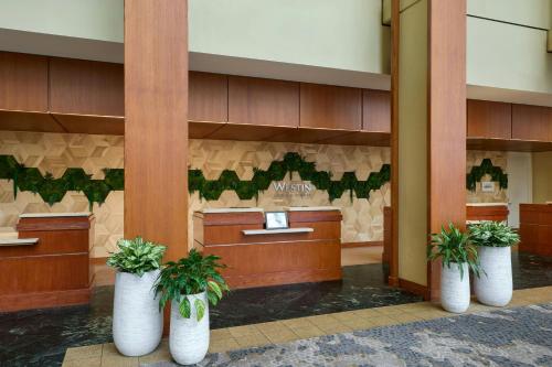 a lobby with three white vases with plants in them at The Westin Atlanta Airport in Atlanta