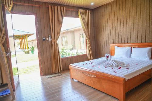 a bedroom with a large bed and a sliding glass door at Bàu Trắng Garden in Ấp Nhơn Hòa