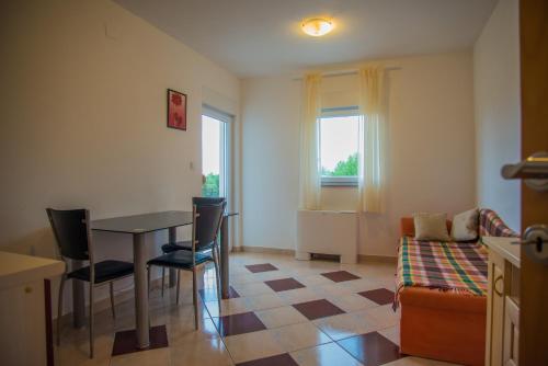 - un petit salon avec une table et des chaises dans l'établissement Apartments Nina, à Promajna